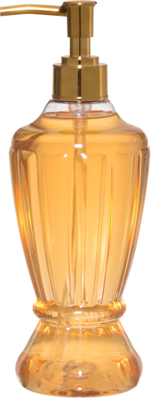 A soap or lotion dispenser with a gold pump and a glass container filled with orange liquid.