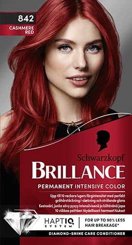 En kvinna med ljus röd hår, ler, i svart topp, på hårfärgningsförpackning märkbar 'Schwarzkopf Brillance'.