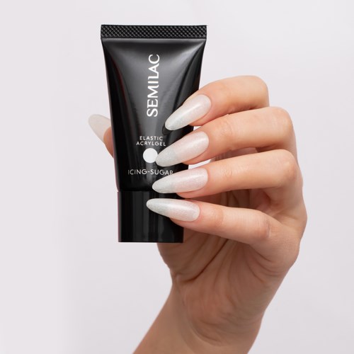 A hand with long, white nails holds a black tube labeled SEMILAC, describing a gel product.
