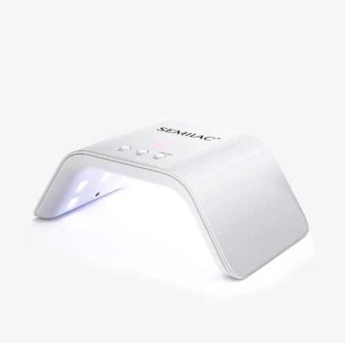 Ein weißes Gerät mit Bogenform und LED-Lichtern, beschriftet SEMILAC, zum Aushärten von Nagellack.