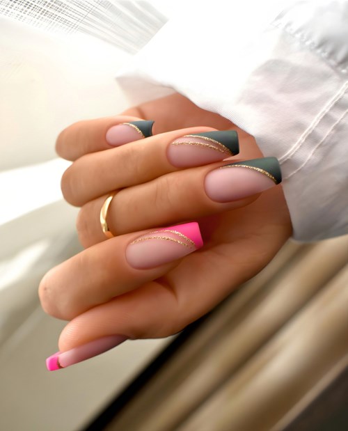 Dekorative Nägel mit Pink, Grün und Gold auf Nägeln, gehalten mit Hand in weißem Hemdärmel.