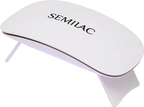 A white device with the word 'SEMILAC'. It has a curved shape with small legs and a purple light underneath.