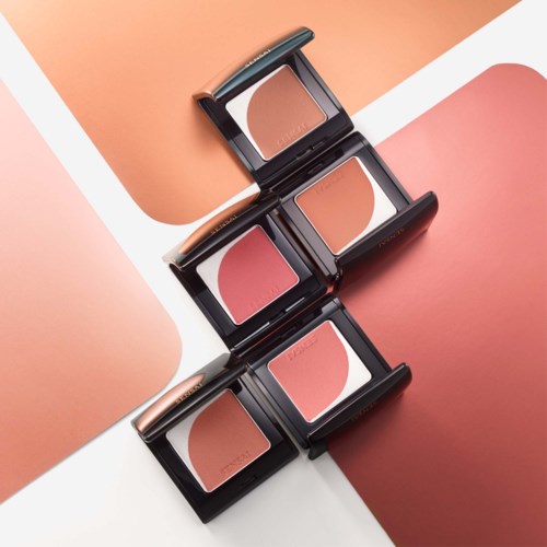 Three blush compacts are arranged vertically, each with a mirror and different shades of pink and orange.