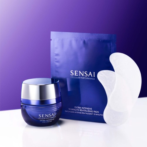 Das Bild zeigt ein blaues Glas mit Augencreme, ein Paket mit revitalisierenden Pads und eine weiße Augenmaske auf einer weißen Oberfläche.