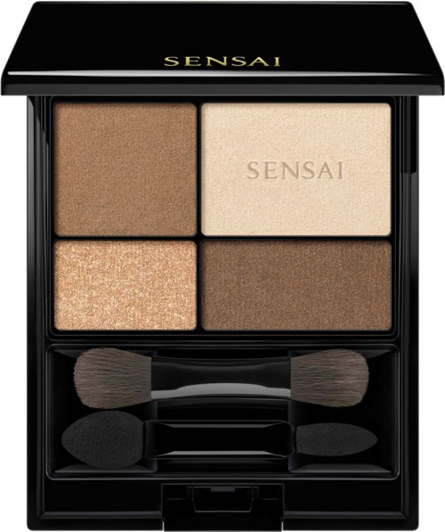 Een compact met vier oogschaduwtinten in beige en bruintinten en drie kleine borstels.