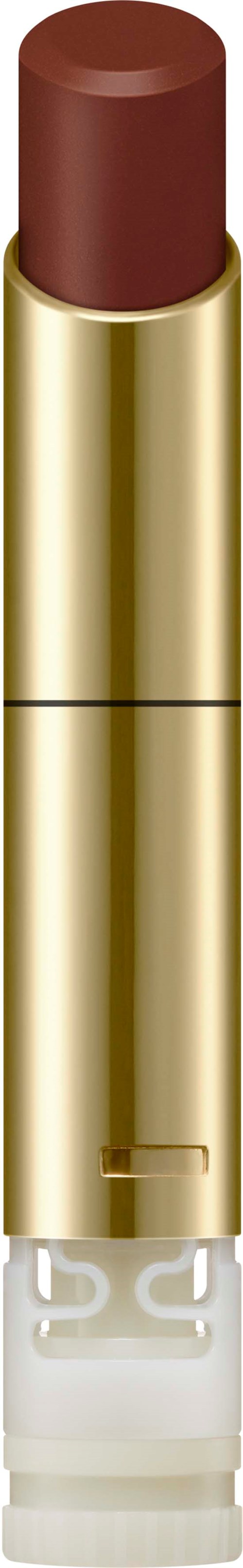 A lipstick with a gold case and a brown shade, standing upright.