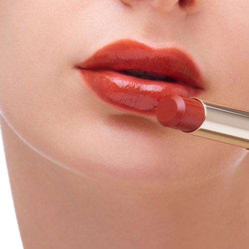 Close-up of lips being colored with lipstick by a person.