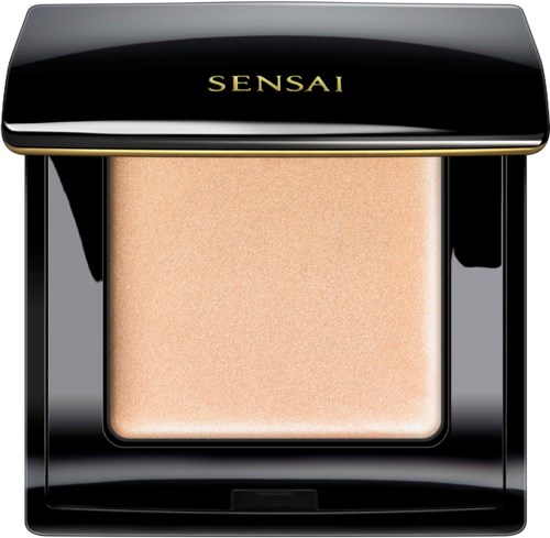 Een zwart, glanzend compact met goudkleurige letters 'SENSAI' en een beige poeder.