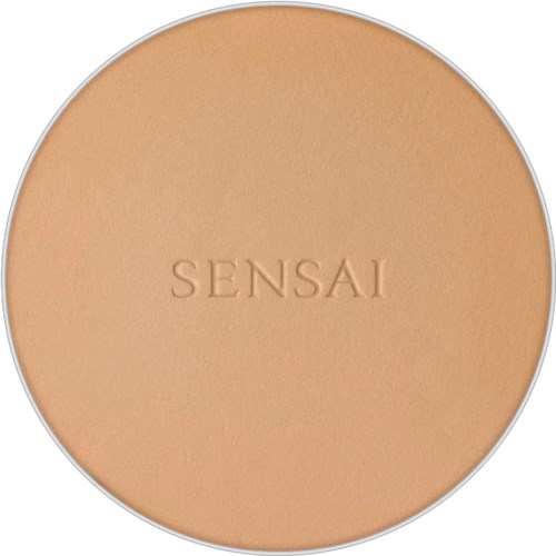 Eine runde Make-up-Box mit eingraviertem Wort 'SENSAI' in der Mitte, hellbeige Farbe.