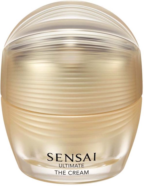 Een potje Sensai Ultimate The Cream, goudkleurig met horizontale lijnen, ziet er luxe en elegant uit.