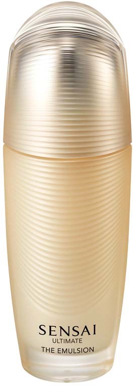 Eine goldfarbene zylindrische Flasche mit abgerundetem Deckel. Das Etikett zeigt, dass es sich um Sensai Ultimate Emulsion handelt.