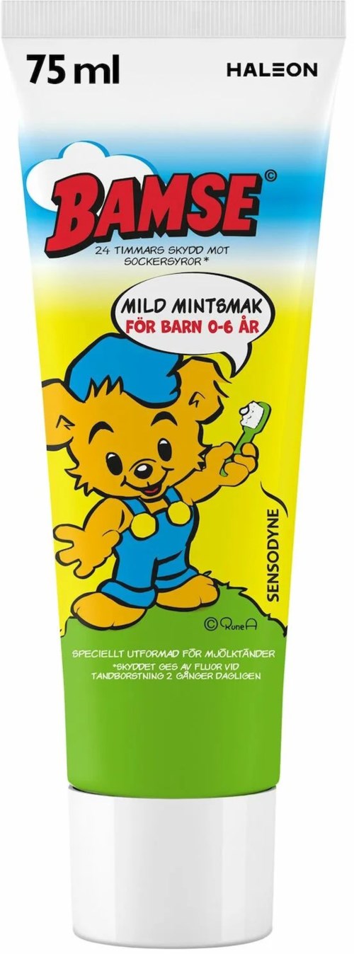 A tube of children's toothpaste with a cute cartoon bear holding a toothbrush, labeled for mild mint flavor.