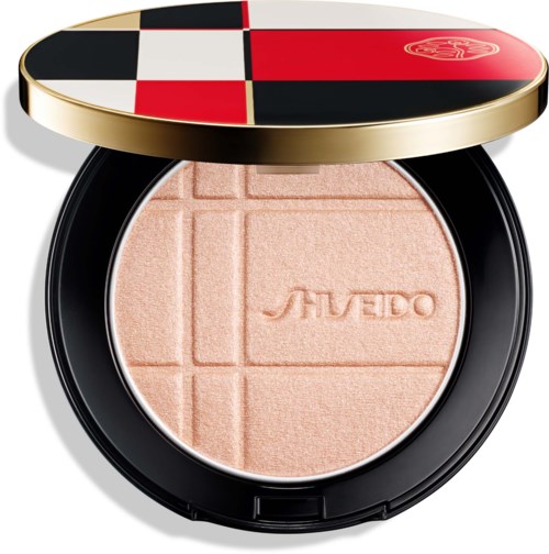 Öppnat puderlock med apelsinfärgad pressad puder, präglad med varumärket Shiseido och geometriska linjer.