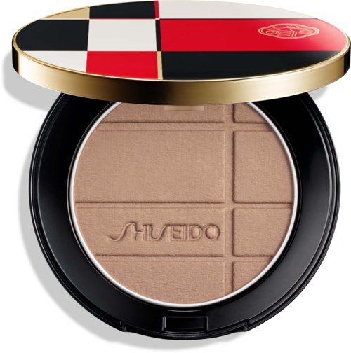 En kompakt med beige puder och det inpräglade varumärket Shiseido, i ett svart skal med ett färgglatt lock.