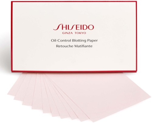 Eine Schachtel mit dem Aufdruck 'SHISEIDO' enthält ölkontrollierende Blotting-Paper, mit einigen Papieren ausgebreitet.