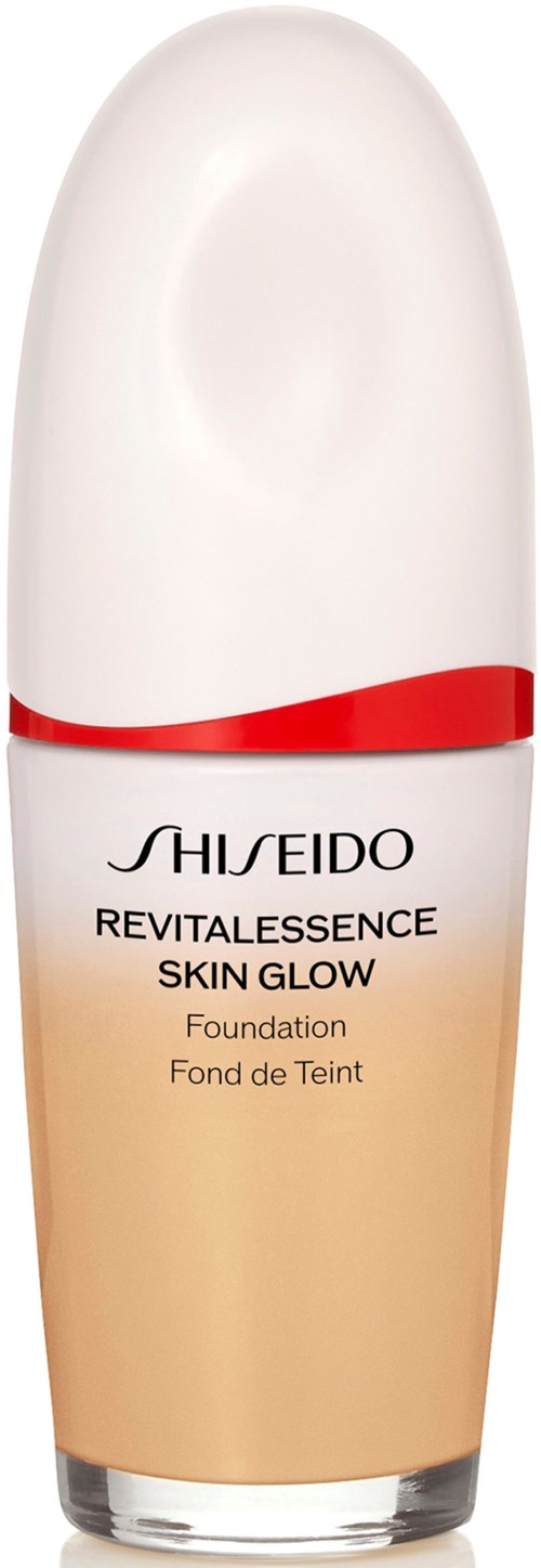 En flaska med Shiseido skin glow foundation med vit lock och beige bas. Text på flaskan i svart.