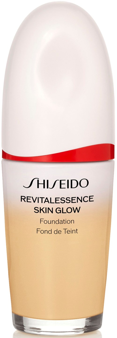 A bottle of Shiseido RevitalEssence Skin Glow foundation with a mostly white cap and beige liquid inside.
