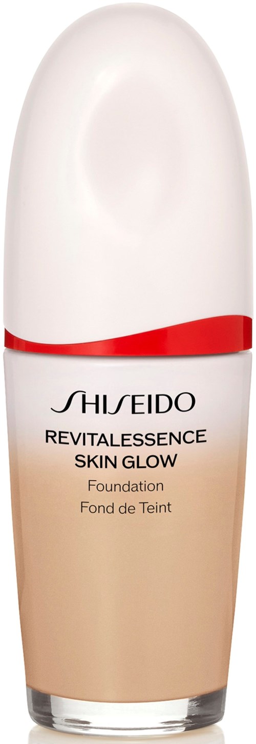 A bottle of Shiseido foundation named Revitalerrance Skin Glow with a white and beige design and a red band.