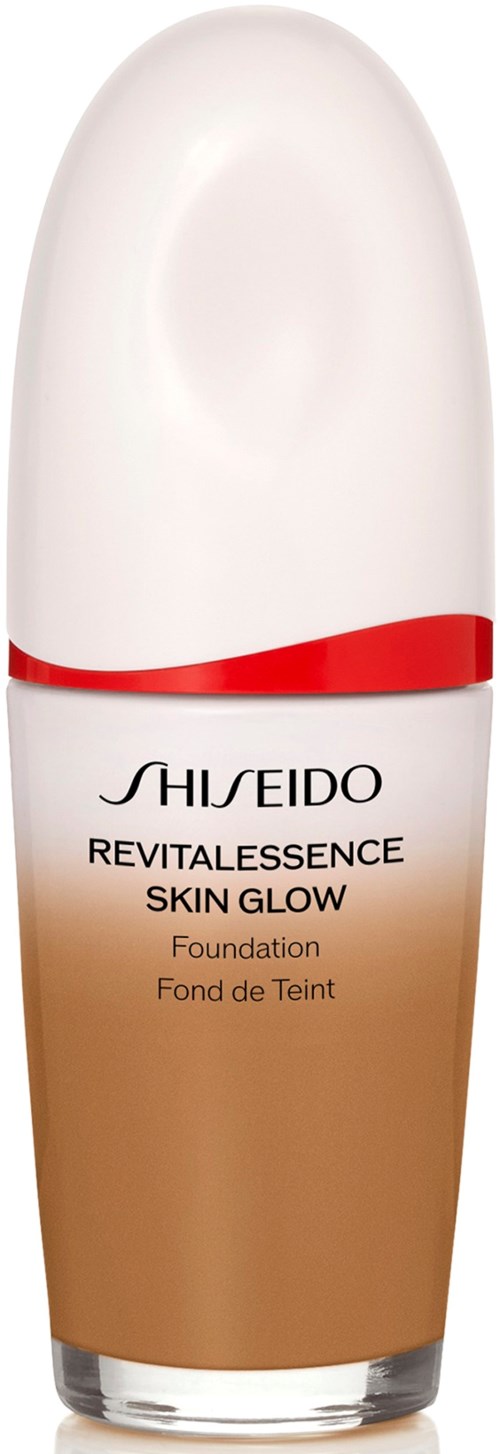A bottle of Shiseido Revitalessance Skin Glow foundation with a white top, red ribbon, and beige bottom.