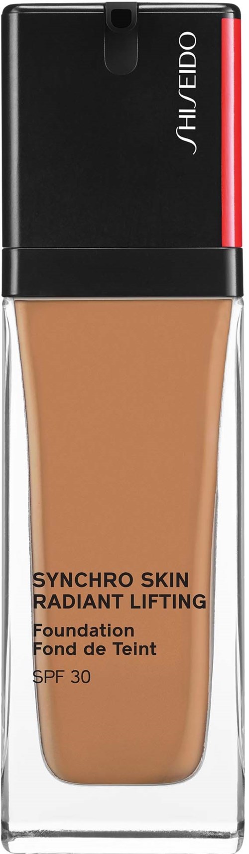 Sävyvoidepullo, jossa musta ja punainen korkki, nimeltä 'Synchro Skin Radiant Lifting'. Pullo on läpinäkyvä ja näyttää beigeväriä.