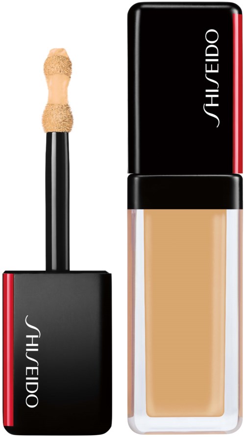 En kosmetikflaska med ett svart lock, röd rand och beige vätska inuti, märkt Shiseido.