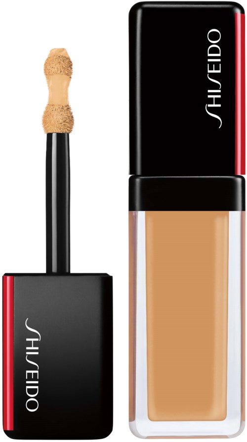En foundationflaska och applikatorspets med svart och röd design, och varumärket Shiseido.
