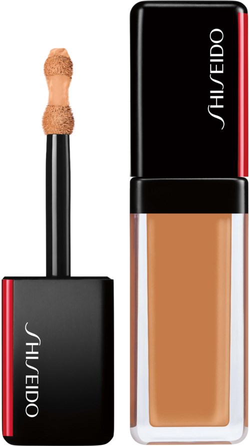 En flytande foundationflaska och applikator med svart lock och röd rand, märkt Shiseido.