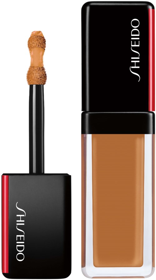 En makeupgrundflaska och applikator med svart och röd design, märkt 'Shiseido'.