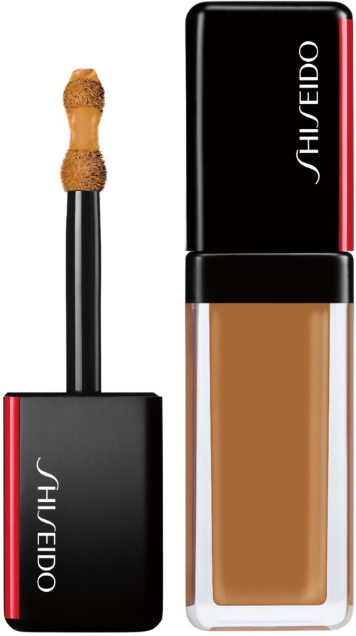 En Shiseido-foundationsflaska med applikator och stängd lock, båda svarta med röda accenter.