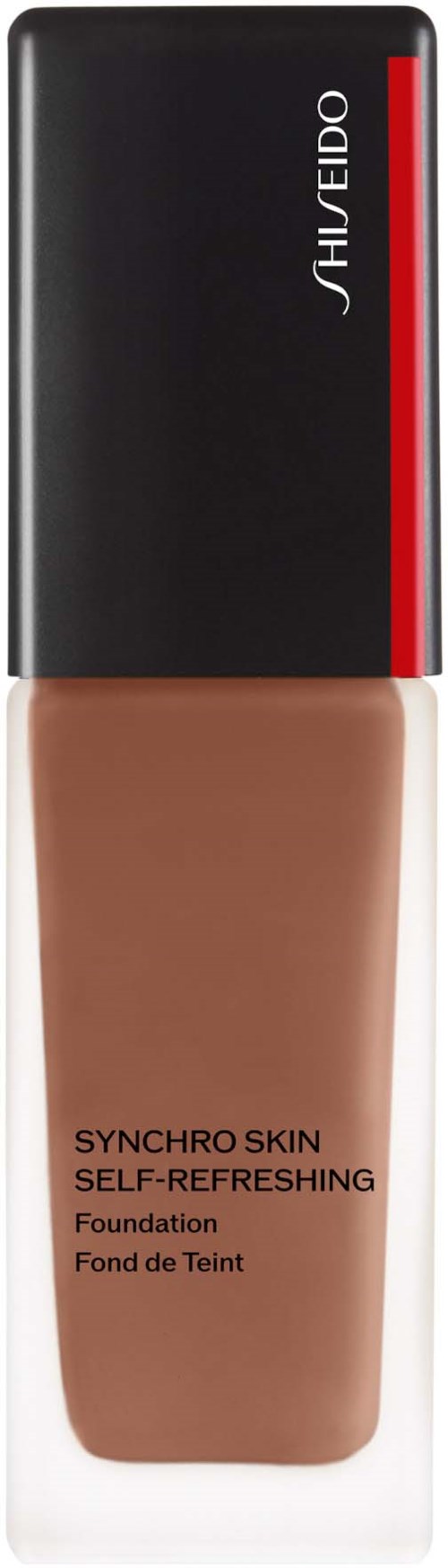 En foundationflaska från Shiseido, med svart och rött lock och beige vätska inuti.