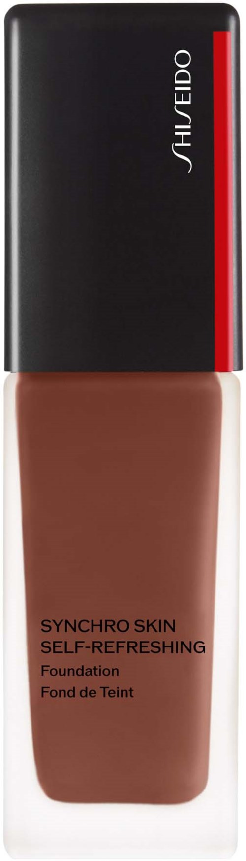 En flaska av Shiseido-grundmjölk med svart lock, röd rand och brun vätska inuti.