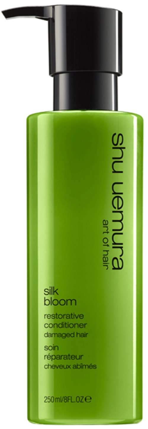 Grüne Flasche mit Pumpkopf, beschriftet 'Shu Uemura, silk bloom, reparierende Spülung bei geschädigtem Haar.'