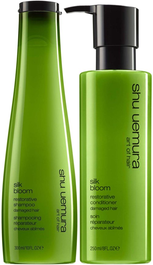 Zwei grüne Haarpflegeflaschen, ein Shampoo und eine Spülung, mit schwarzen Deckeln und einfachen Etiketten.