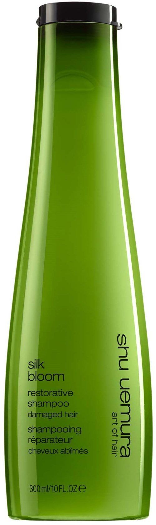 Eine lange, grüne Shampooflasche mit schwarzem Deckel, als Silk Bloom reparatives Shampoo für geschädigtes Haar gekennzeichnet.