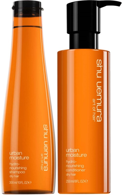Zwei orange Flaschen, eine Shampoo und die andere Conditioner, beide mit 'urban moisture' beschriftet von Shu Uemura.