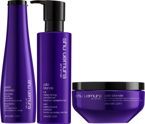 Three hair care products, purple bottles and a jar, labeled Shu Uemura Yubi Blonde for blond hair care.