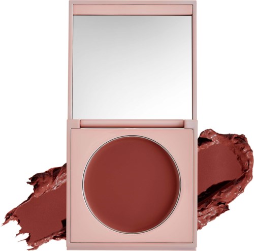 Ett rosa sminkfodral innehåller en rund spegel och rödbrun puder, med puder spillt runt det.