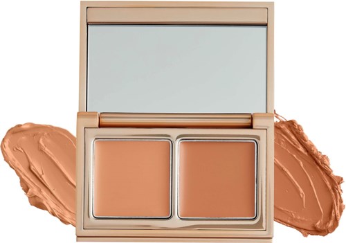 En liten makeuppalett med två foundationskuggor och en spegel, omgiven av uppsminkade räfflor.