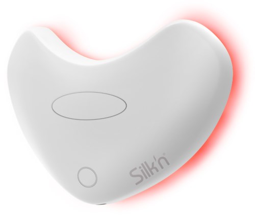 A white silicone device glowing with red light, shaped like a bean or heart, with a button and logo.