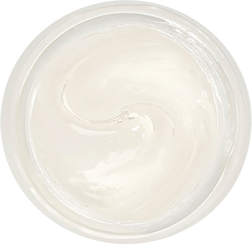 En klar rund skål fylt med glatt hvit krem eller lotion, som svirrer forsiktig inni.