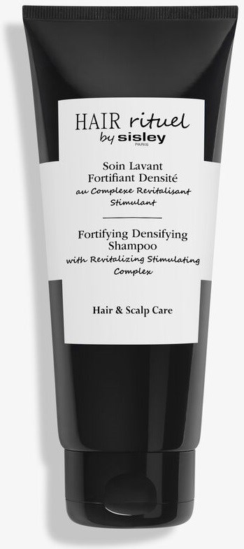 Een zwart-witte shampoo tube met de tekst "Hair rituel by Sisley" voor het versterken en stimuleren van haar en hoofdhuid.