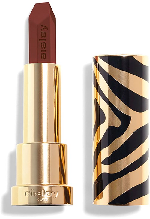 A lipstick with a gold case and a red-brown shade. The cap has black and beige animal print design.