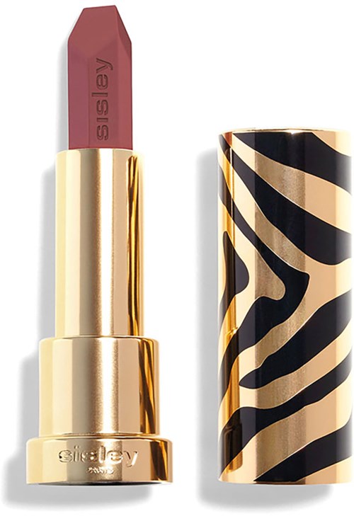 A lipstick with a gold case and a zebra pattern cover nearby.