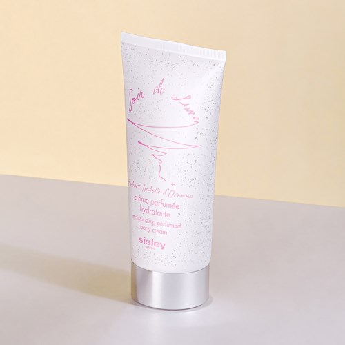 En hvit tube med rosa tekst og sølvhette, merket som parfyme kroppkrem.