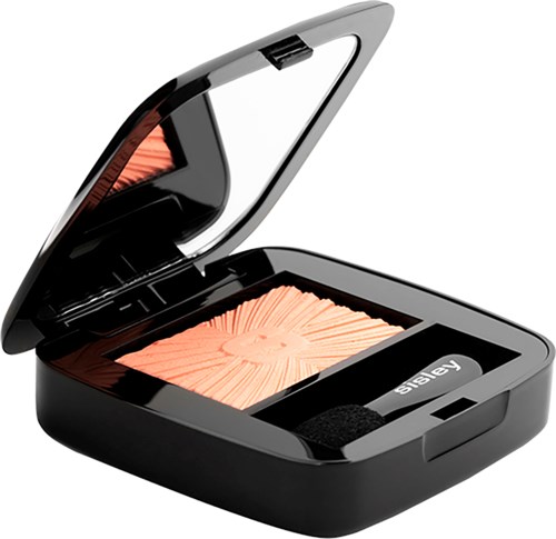 A compact makeup mirror with peach-colored pressed powder inside, labeled 'abay' with a black latch.