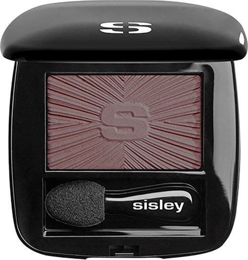 A compact black makeup case with a red blush, sponge applicator, and a logo on top.