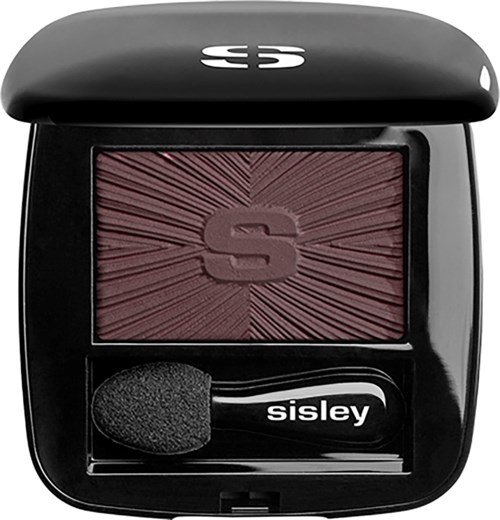 A compact blush case with a pinkish-red color, a sponge applicator, and a black case with a logo on top.