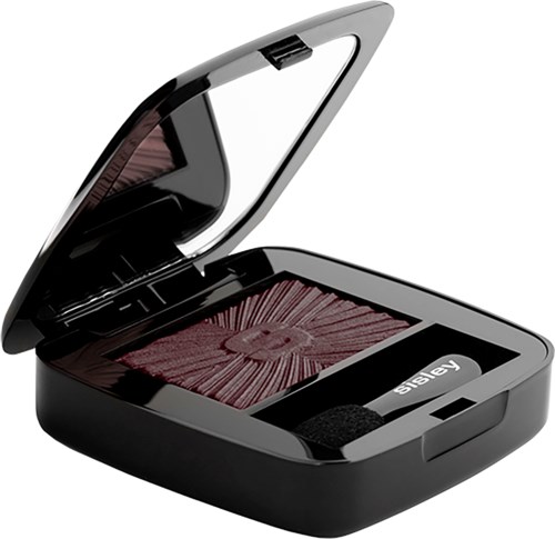 A compact black case is open, revealing dark pink eyeshadow with a circular pattern. It has a mirror inside.
