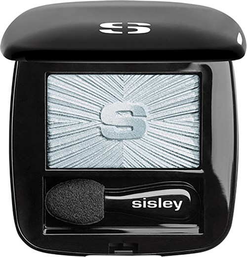 A compact black makeup case with a mirror, a foam applicator, and the letter S on the mirror surface.