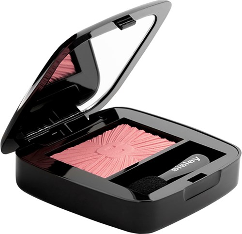 A black compact with pink pressed powder and a mirror inside, with a small black applicator.